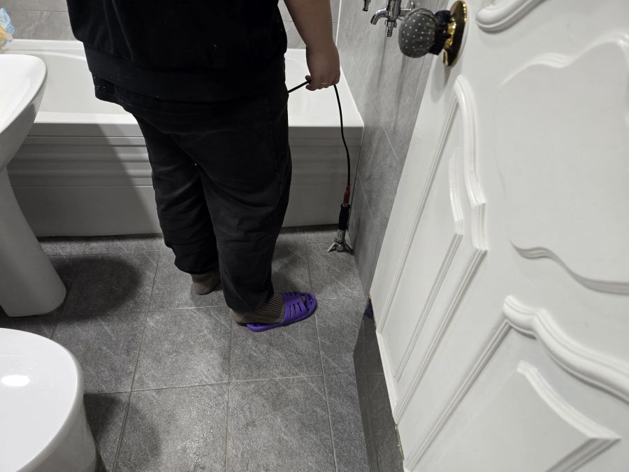 샤워 벽면에 청음봉을 대고 확인하는 장면